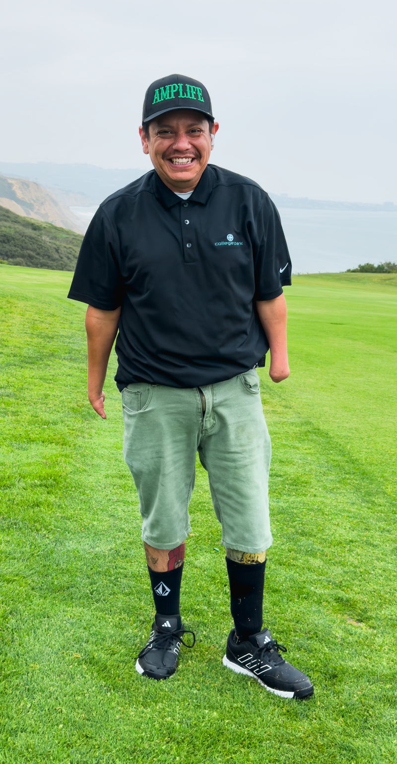 Team Amplife® Ambassador Oscar Loreto, Jr. standing on the fairway at Torrey Pines North Golf Course while wearing the Amplife® Curved Bill Snapback