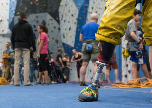 Group of Paradox Sports youth climbers behind a prosthetic leg in focus.