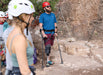 Person with a prosthetic leg using crutches in a rocky outdoor setting