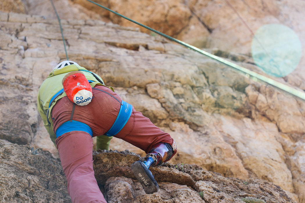 Person rock climbing on a rocky cliff face