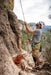 Man climbing a rocky cliff with a helmet and rope