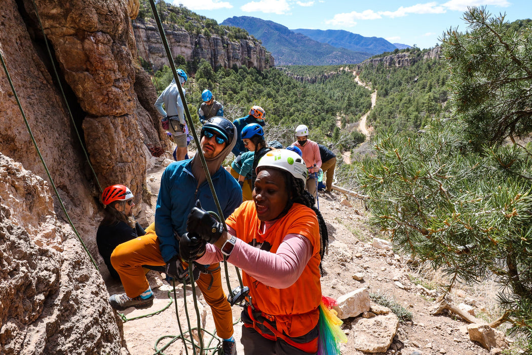Group of people on a rock climbing adventure with mountains in the background