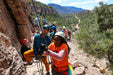 Group of people on a rock climbing adventure with mountains in the background