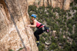 Person rock climbing on a cliff with a scenic background