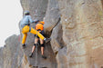 Two climbers on a rocky cliff face with ropes and climbing gear.