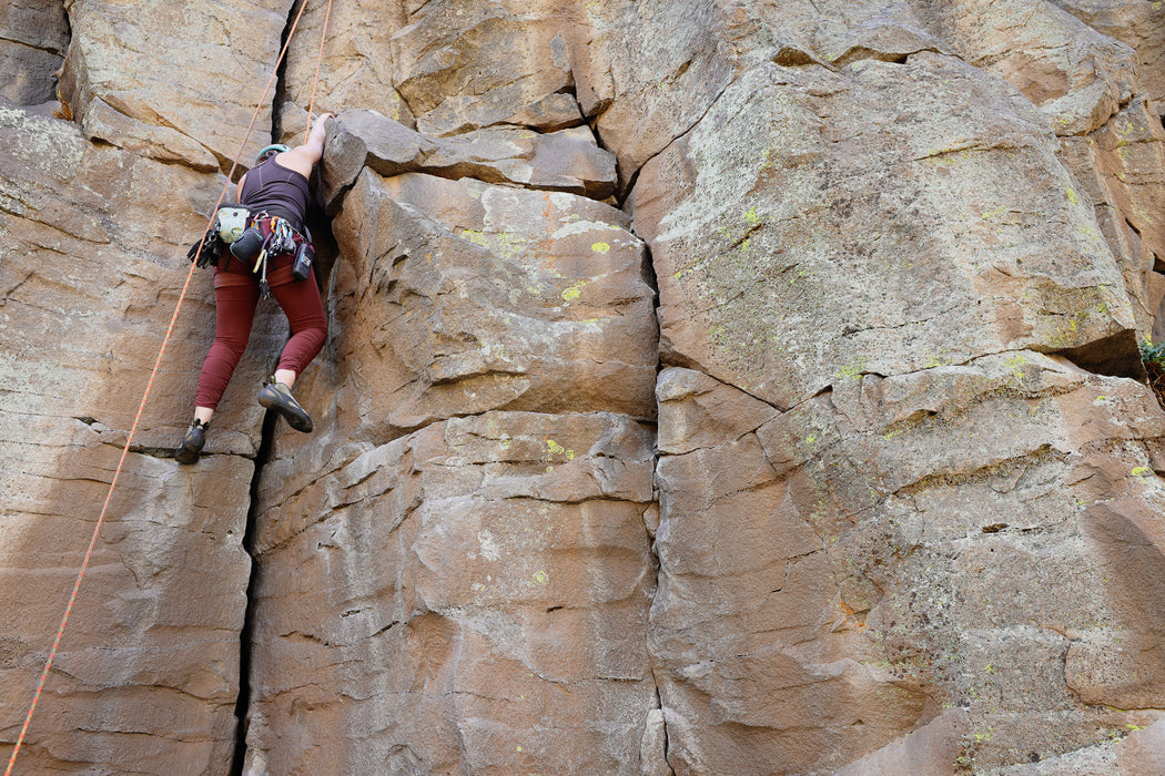 Person rock climbing on a steep cliff face.