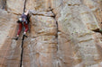 Person rock climbing on a steep cliff face.