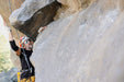 Person climbing a rocky cliff face.