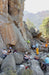 Group of people climbing and exploring rocky cliffs with a scenic background.
