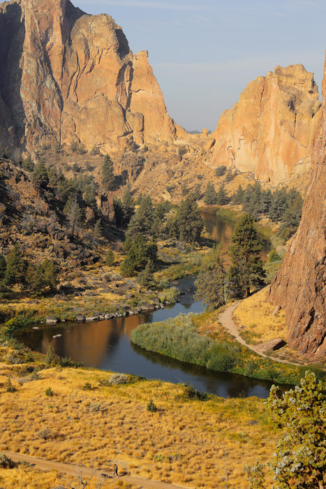Scenic view of a river winding through a canyon with rocky cliffs and greenery.