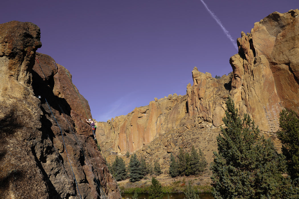 Rugged rock formations with trees against a clear blue sky.