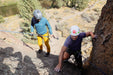 Two climbers on a rock face with ropes and climbing gear.