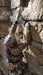Person rock climbing on a rocky wall with climbing gear.