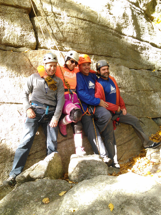 Group of climbers posing on a rocky cliff.