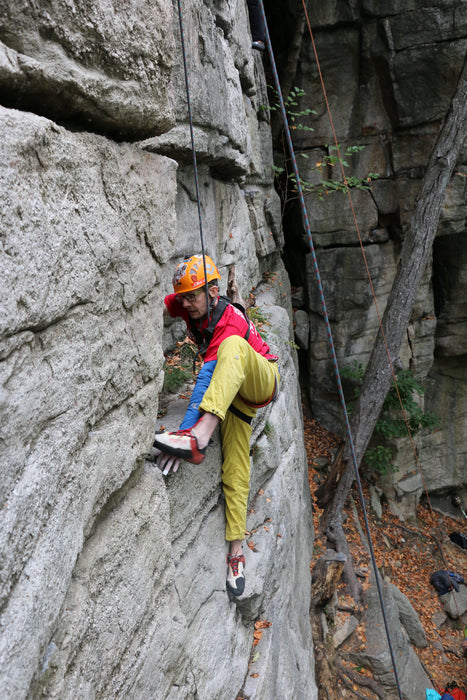 Person rock climbing on a rocky cliff face.