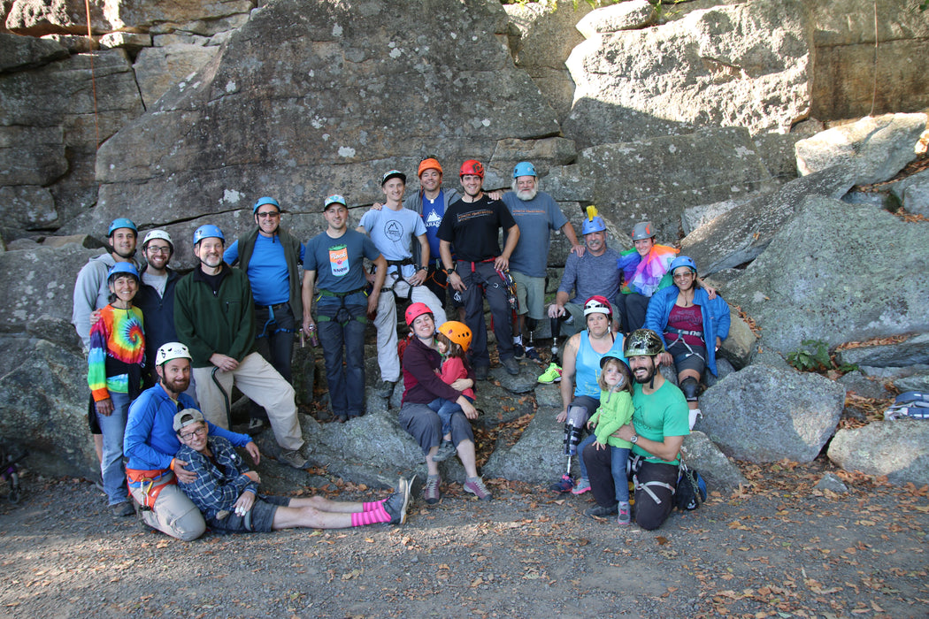 Group of people posing for a photo in a rocky outdoor setting.