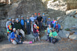 Group of people posing for a photo in a rocky outdoor setting.