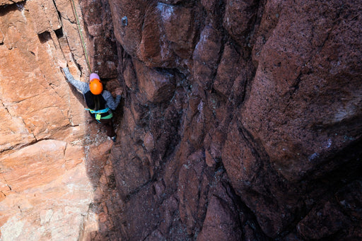 Person climbing a narrow rock crevice