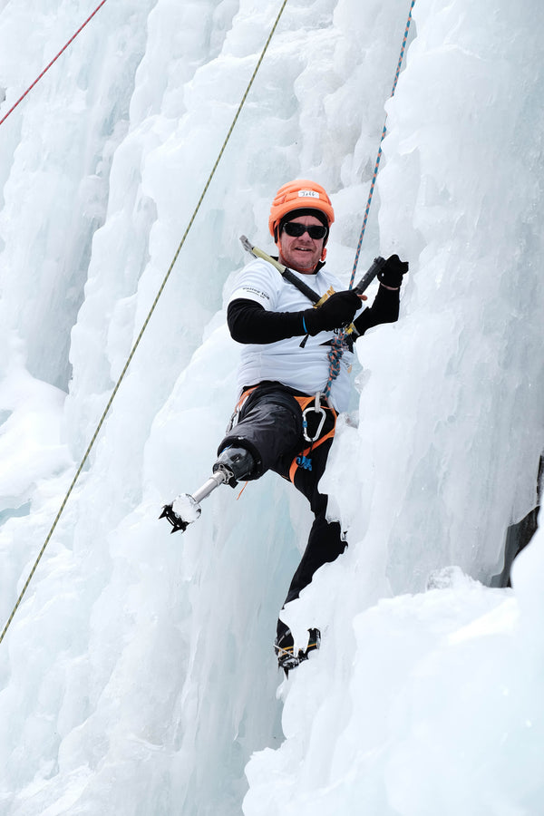 Person with right above knee amputation on the edge of an ice wall