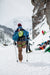 Person with a right above knee amputation standing with forearm crutches with ice climbing gear on
