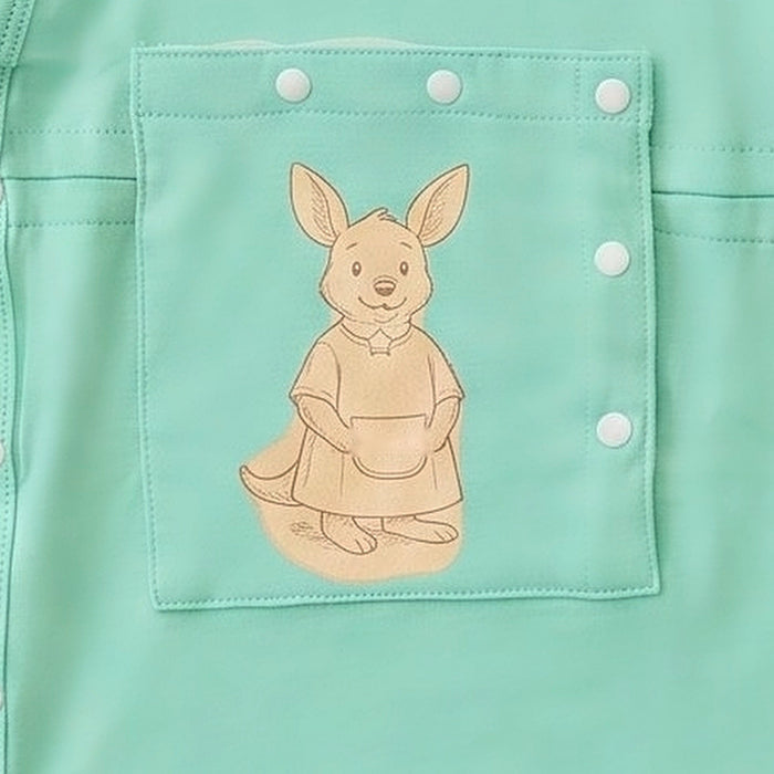 Close-up of the snap-closed chest pocket on the PediaTech Apparel LineWear Central Line Access Baby Gown in mint green (Calm Mint Edition), printed with an illustrated kangaroo in a dress holding a basket