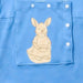 Close-up of the snap-closed chest pocket on the PediaTech Apparel LineWear Central Line Access Baby Gown in light blue (Sky Lullaby Edition), printed with an illustrated kangaroo in a dress holding a basket