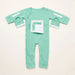 Front angle of the PediaTech Apparel LineWear Central Line Access Baby & Toddler Bodysuit in mint green (Calm Mint Edition) with the chest pocket flap opened to show its white lining and both sleeve openings unsnapped, laid flat against an off-white background