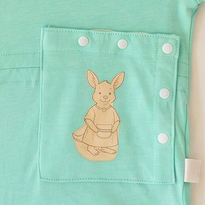 Close-up of the snap-closed pocket over the abdomen on the PediaTech Apparel TubeWear G/J Tube Access Baby Gown in mint green (Calm Mint Edition), printed with an illustrated kangaroo in a dress holding a basket