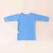 Back angle of the PediaTech Apparel TubeWear G/J Tube Access Baby Gown in light blue (Sky Lullaby Edition) with white tubing guides at the shoulder and lower back, laid flat against an off-white background