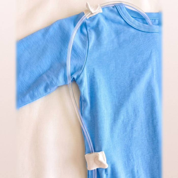 Close-up of clear tubing threaded through the white guides at the shoulder and lower back of the PediaTech Apparel TubeWear G/J Tube Access Baby Gown in light blue (Sky Lullaby Edition)