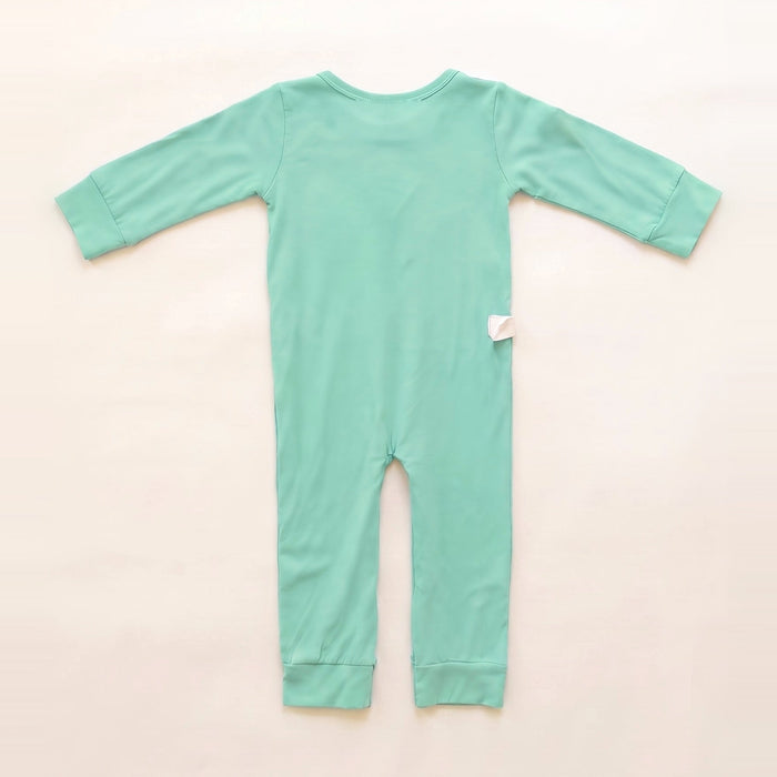 Back angle of the PediaTech Apparel TubeWear G/J Tube Access Baby & Toddler Bodysuit in mint green (Calm Mint Edition) with a white tubing guide at the lower back, laid flat against an off-white background
