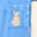 Close-up of the snap-closed pocket over the abdomen on the PediaTech Apparel TubeWear G/J Tube Access Baby & Toddler Bodysuit in light blue (Sky Lullaby Edition), printed with an illustrated kangaroo in a dress holding a basket