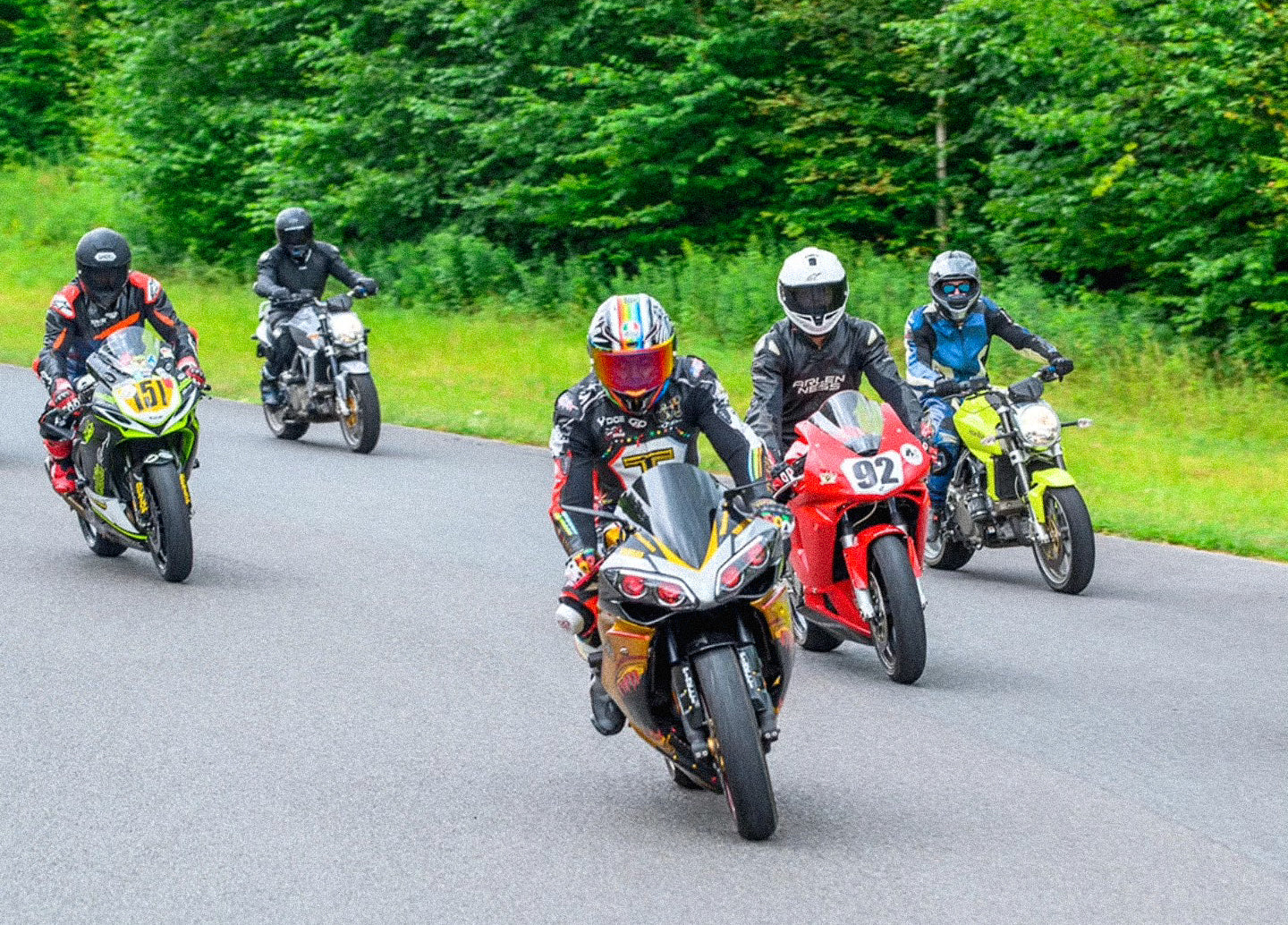 Ride Again Foundation motorcyclists on a winding road with trees in the background