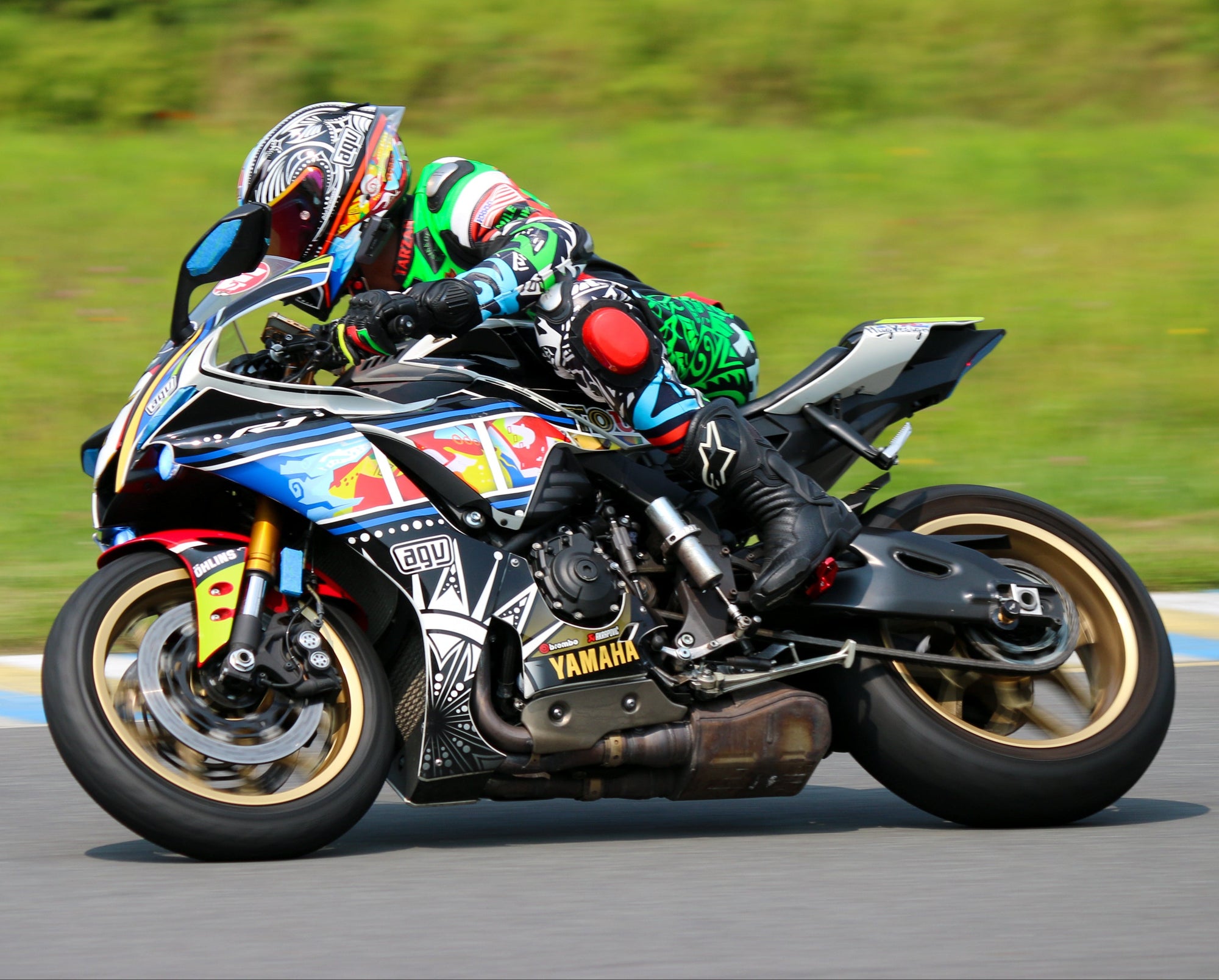 Team Amplife® Ambassador Joseph Forde racing on a track on his motorcycle with greenery in the background