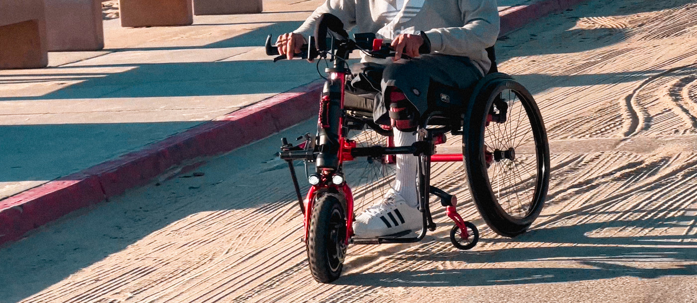 Rio Mobility Firefly 2.5 in use on the sand above concrete on a beach's parking lot.