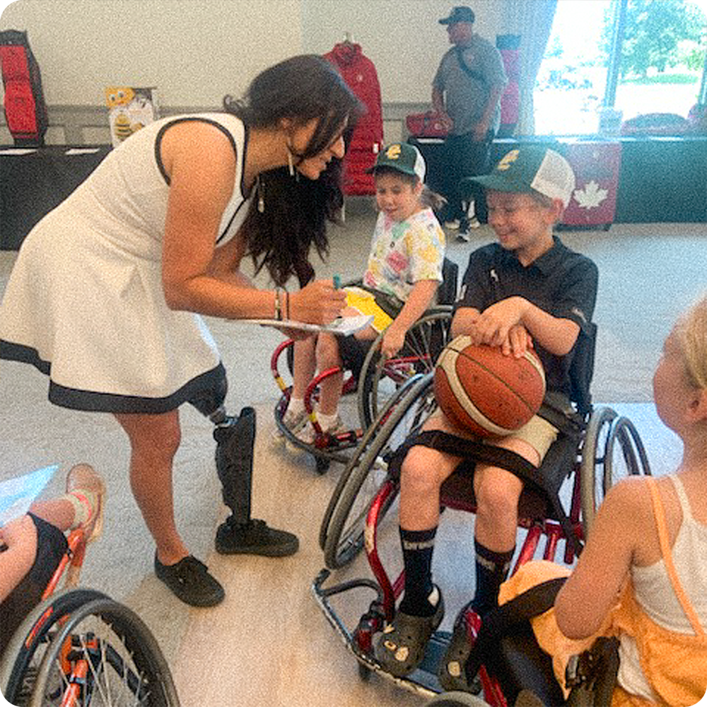 Team Amplife® Ambassador Rouzalin Hakim interacting with children wheelchair basketball players