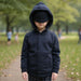 Child wearing a Sense-ational You QuietSense Sound Reducing Sensory Navy Youth Hoodie in a park