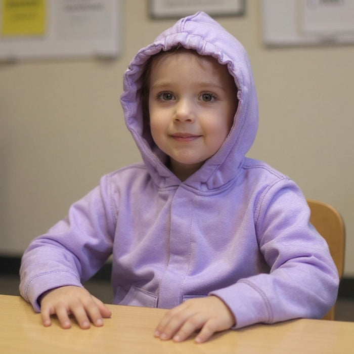 Child wearing a Sense-ational You QuietSense Sound Reducing Sensory Lilac Youth Hoodie sitting at a table indoors
