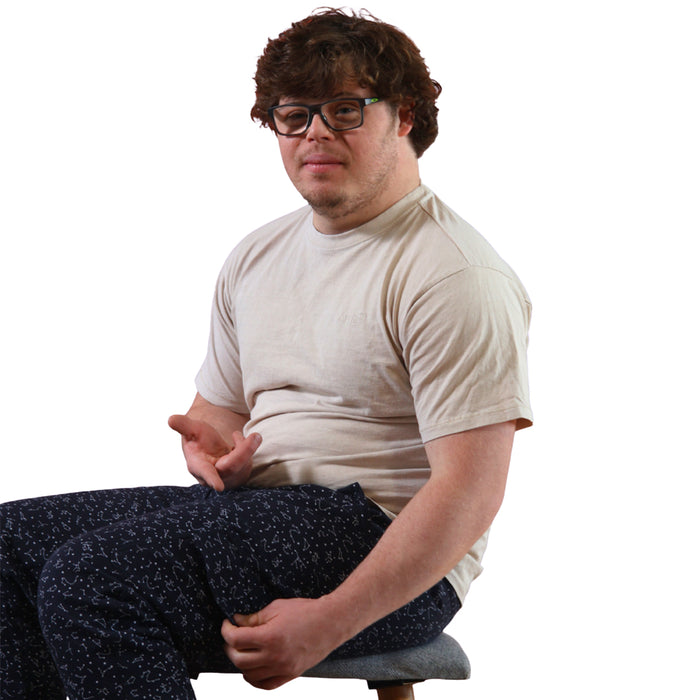 Person wearing a Sense-ational You Sensory Friendly Fidget Constellation Joggers sitting on a stool against a white background