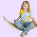 Child sitting on wood board while wearing a Sense-ational You Sensory Friendly Fidget Youth Grey Joggers on a white background