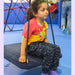 Child wearing a Sense-ational You Sensory Friendly Fidget Youth Constellation Joggers on a swing at an indoor playground