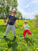 Two children playing in a grassy field with yellow flowers on a sunny day while wearing Sense-ational You Sensory Friendly Youth T-Shirts