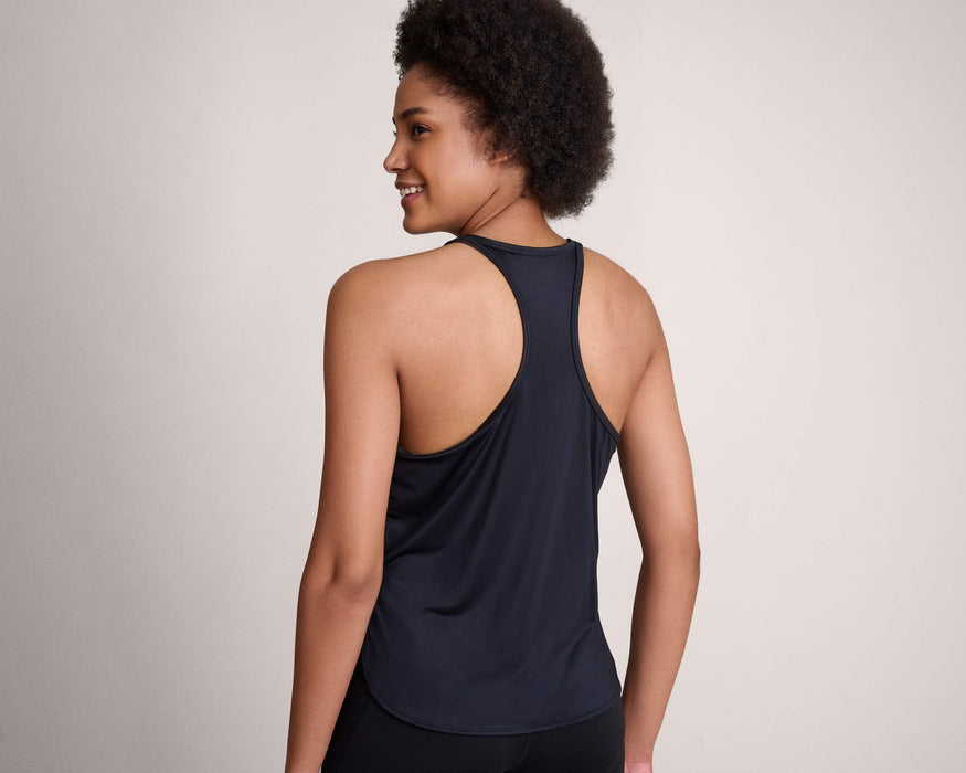 Back angle of a model with short dark curly hair wearing Slick Chicks Adaptive Athletic Tank Top against a plain beige background