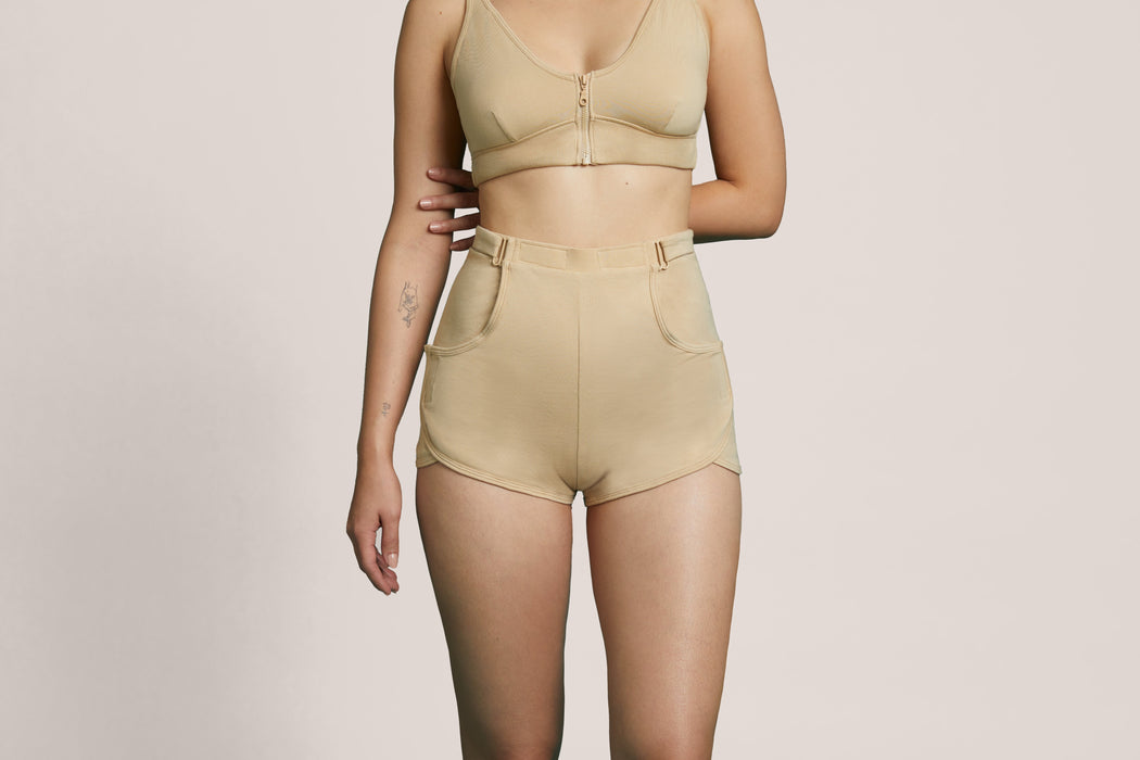 Front angle of a model wearing Slick Chicks Adaptive Lounge Short in beige against a beige background