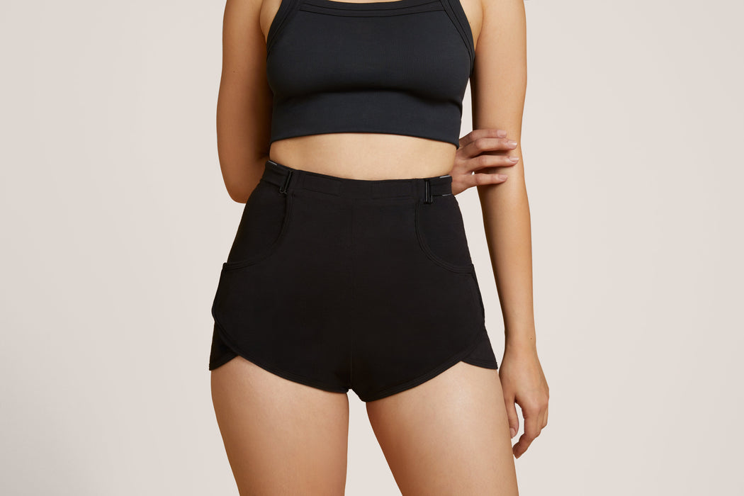 Front angle of a model wearing Slick Chicks Adaptive Lounge Short in black against a beige background