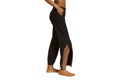 Side angle of a model wearing Slick Chicks Adaptive Side Zip Joggers in black against a plain white background