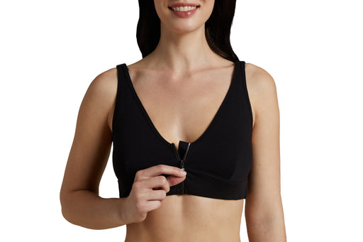 Close up of a model wearing Slick Chicks Adaptive Wireless Front Zip Bra in black, demonstrating the front zipper by unzipping with one hand, against a white background