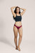 A model wearing Slick Chicks Adaptive Bikini Brief Panty in beige, standing against a plain beige studio background