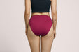 Rear angle of a model wearing Slick Chicks Adaptive High Waist Brief in plum against a plain light beige studio background