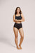 A model wearing Slick Chicks Adaptive Leakproof Underwear in black against a plain light beige studio background